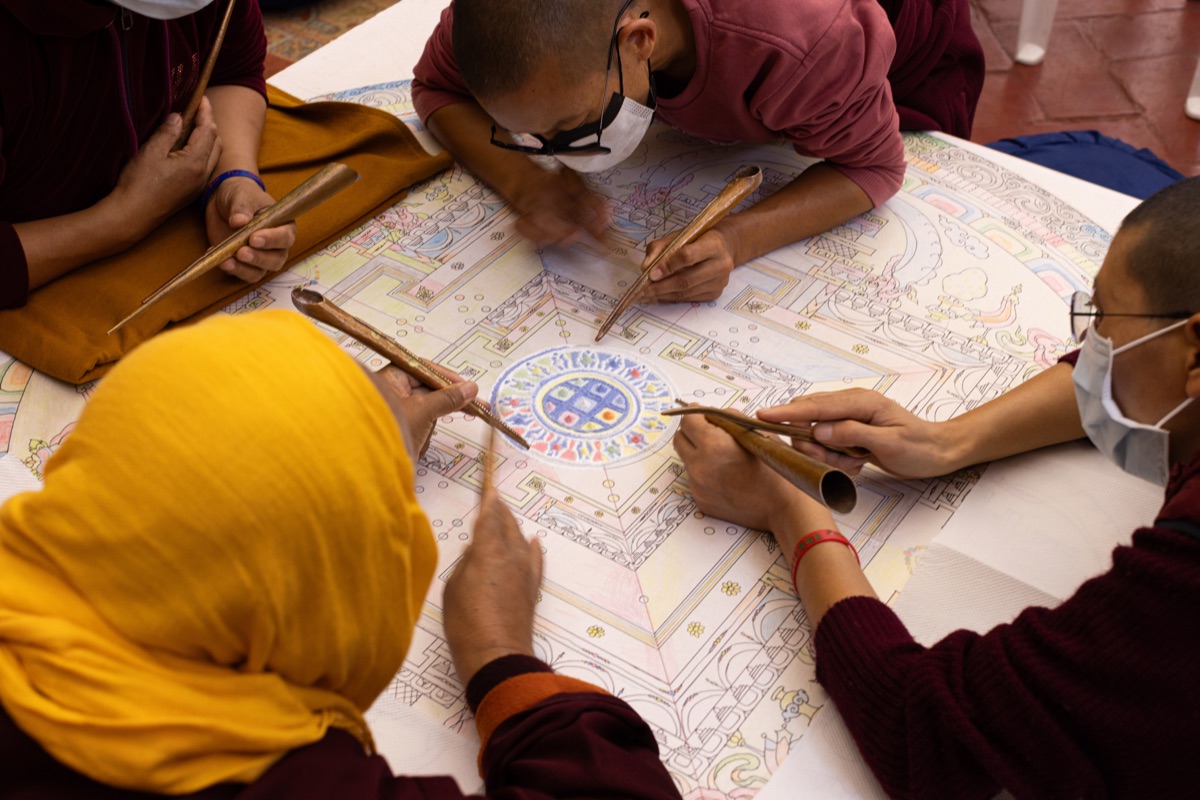 Monastics painting a mandala together