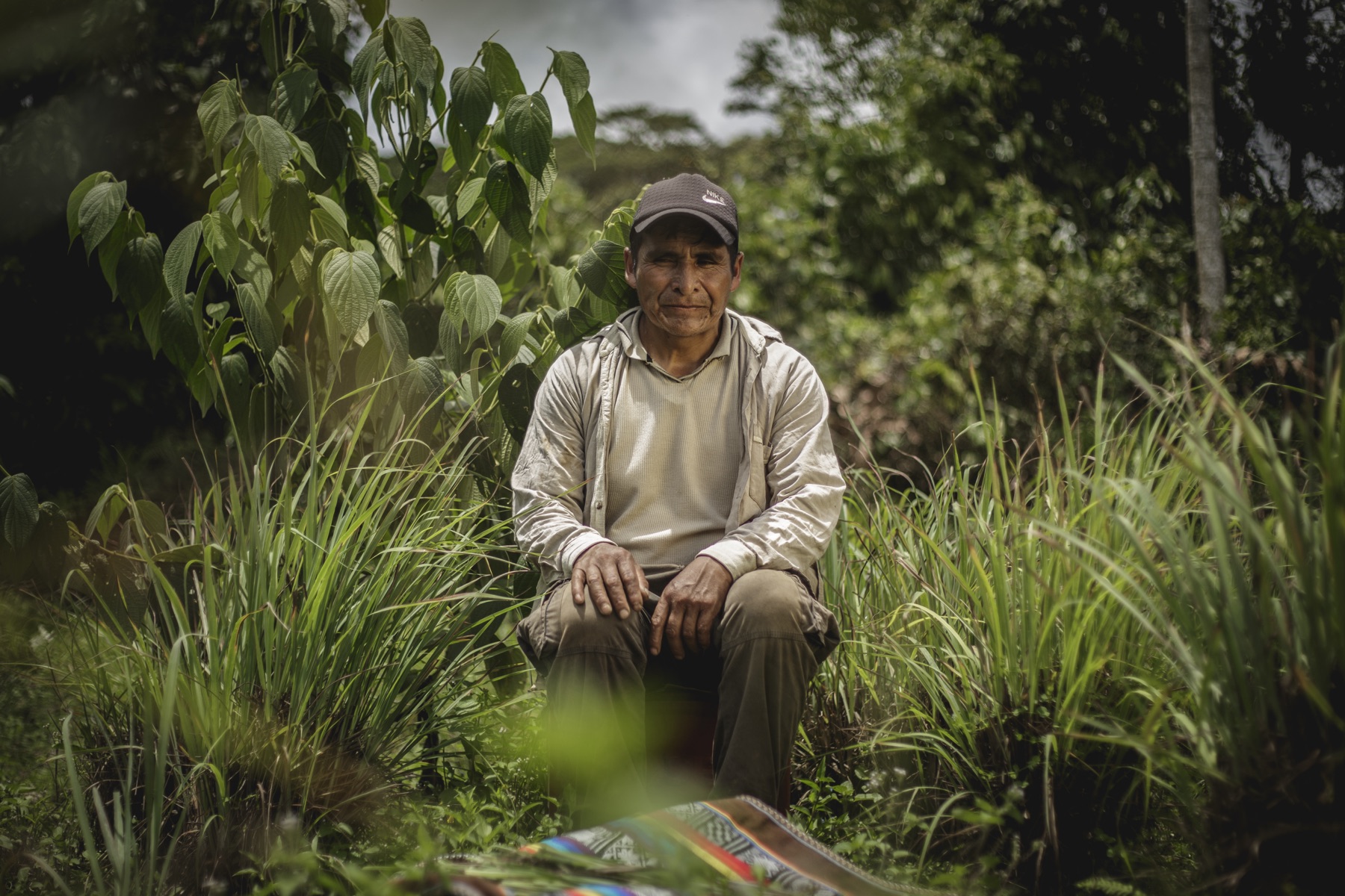 Vicente Quispe Soncco in the jungle carrying a woven manta