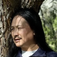 Dr. Nida Chenagtsang standing beside a tree
