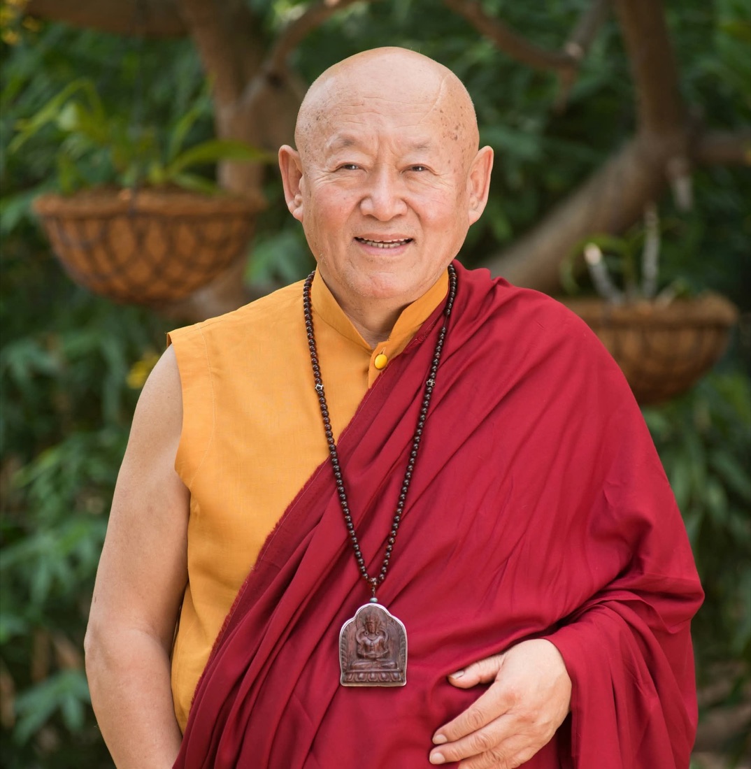 Tibetan Buddhist master in red and saffron robes