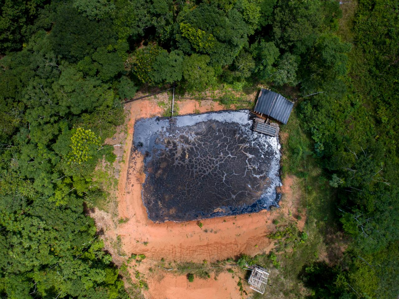 Aerial view of a waste pit cut into the forest
