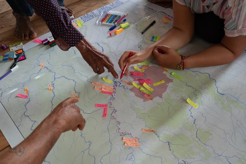 Hands marking a map of the territory